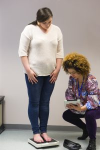 Nurse weighing woman